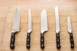 Cinco tipos diferentes de cuchillos de cocina alineados sobre una encimera