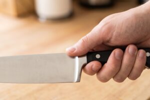 Mano que sostiene un cuchillo de chef con la empuñadura apretada